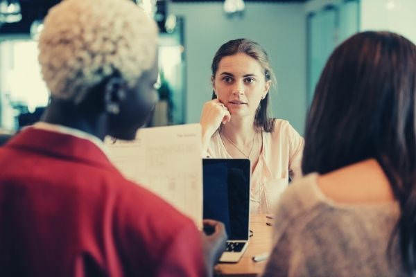 white woman looking at her talking colleagues employee recognition messages years of services