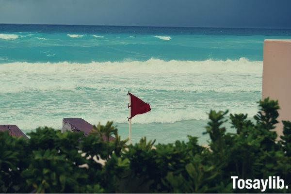 red hurricane warning flag near body of water