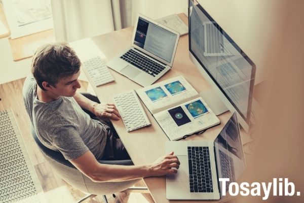 man using three computers researching