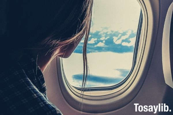 woman looking outside the plane window travel