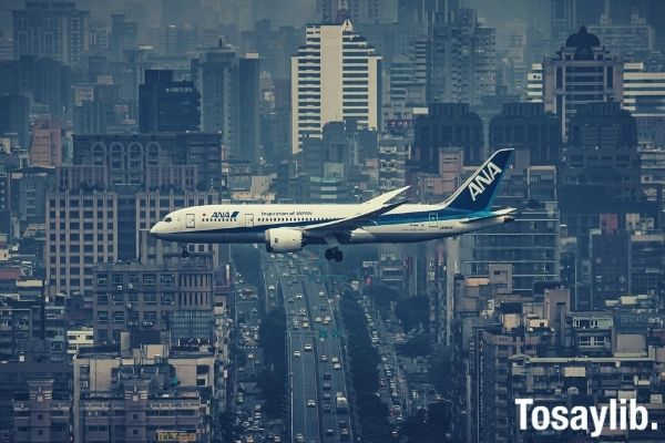 white airplane flying over the city