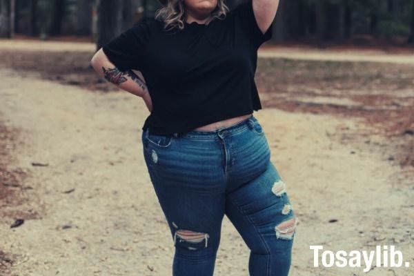 woman in black shirt and blue denim standing