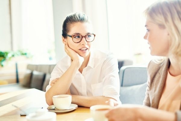 two friendly colleagues relaxing having talk