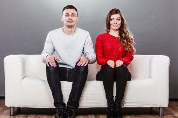 shy woman man sitting on sofa red sweater