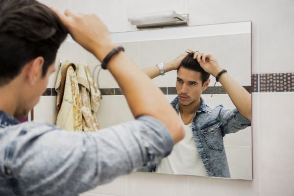 reflection young man bushing hair mirror