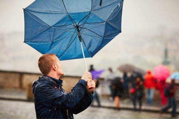 27 rain city young man holding blue umbrella broken