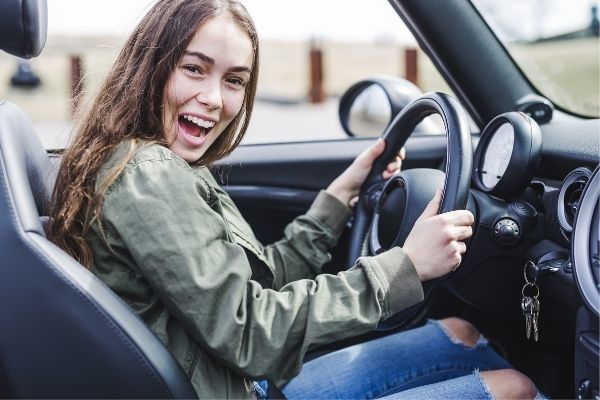 young brunette woman new car smiling