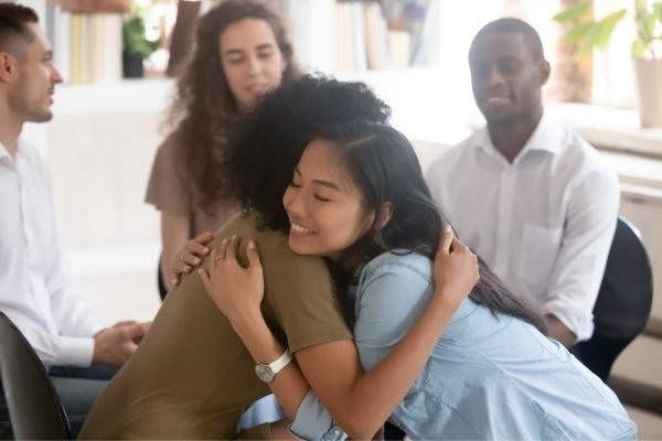 01 asian african women embracing giving psychological support