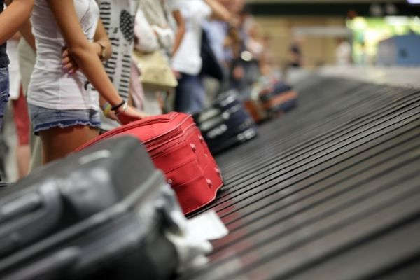 28 suitcase on luggage conveyor belt baggage people waiting