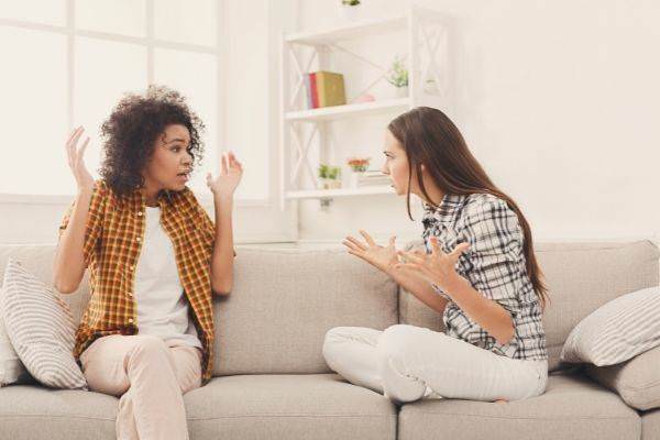 03 two female friends sitting on sofa talking about something