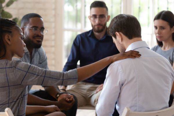 08 group of people praying over for the depressed man