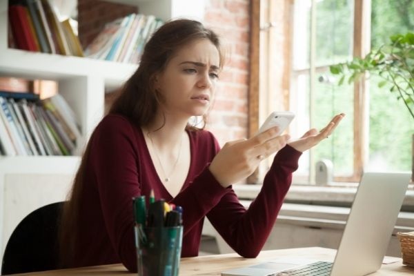 frustrated woman having problem not working holding smartphone