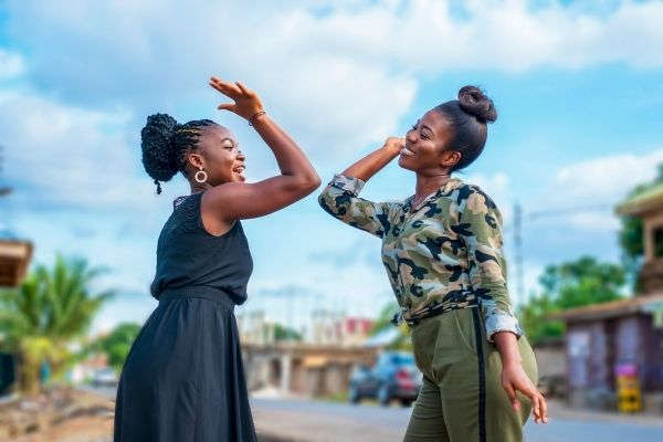 two beautiful african women happily laughing about to high fivetwo beautiful african women happily laughing about to high five