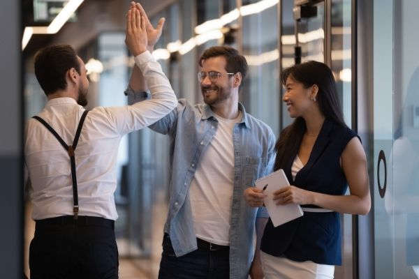 friendly male colleagues giving high five
