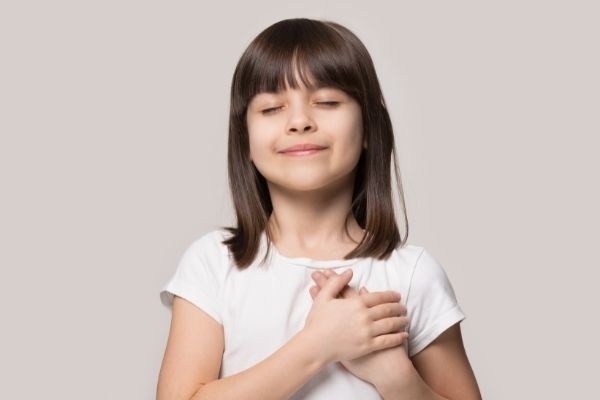 04 little sincere adorable girl closed eyes hands on chest