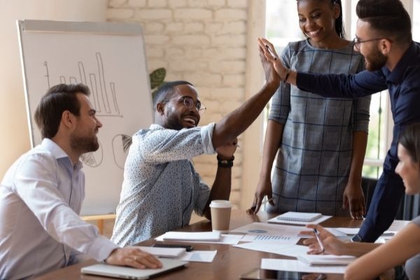 happy african american male manager sitting high five