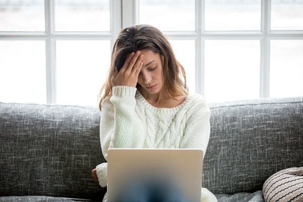 frustrated sad woman in front of laptop feeling tired worried