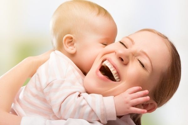 happy cheerful family mother baby kissing happy mother