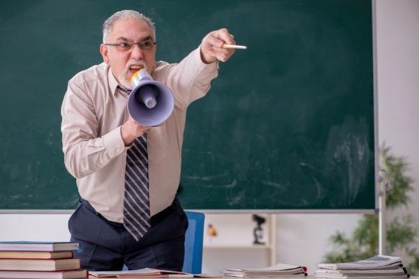 old male teacher classroom shouting pointing using stick