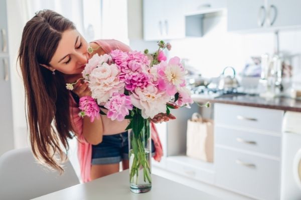 valentines day woman smelling bouquet peonies