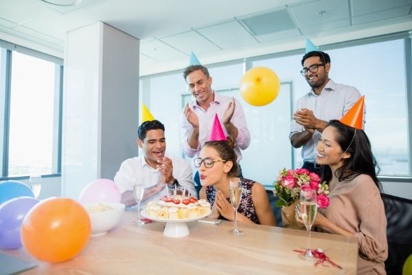 smiling colleagues celebrating birthday woman office