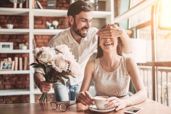 surprise beautiful romantic couple cafe young covering eyes flower