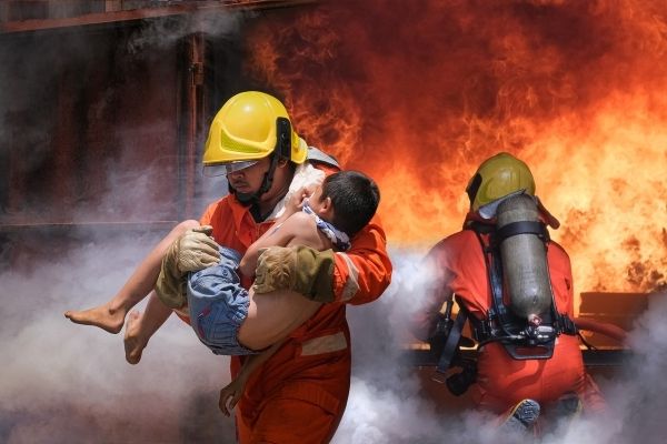 firefighter holding child boy save him