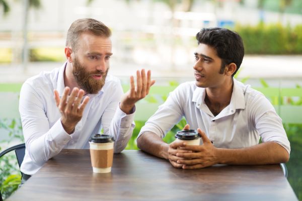 two-male-friends-in-white-drinking-coffee-talking