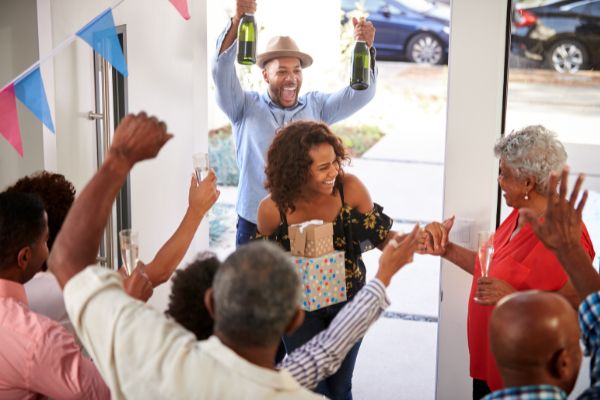 three generation family throwing surprise party gifts champagne