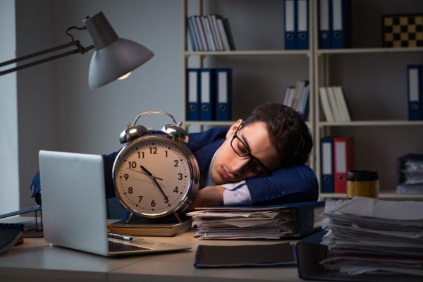 businessman falling asleep during long hours clock laptop