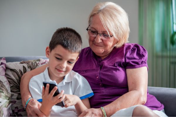 04 happy grandmother cute grandson using smartphone