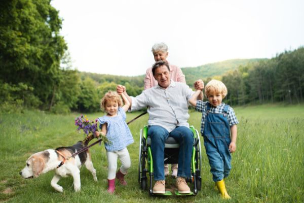 10 small children senior grandparents dog sitting on wheel chair