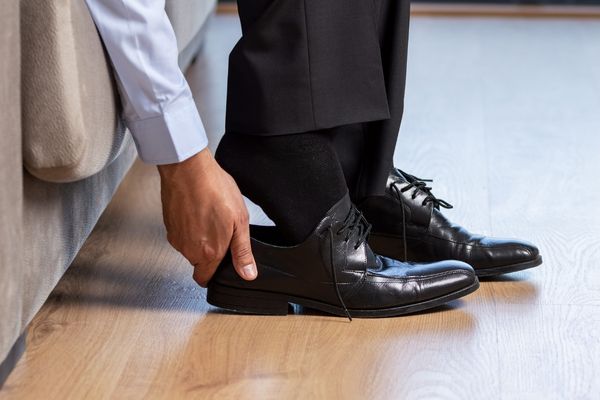 businessman taking off shoes after work
