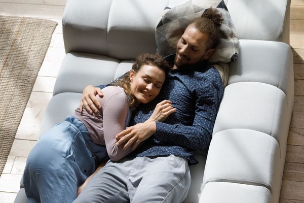 happy peaceful couple resting on soft couch
