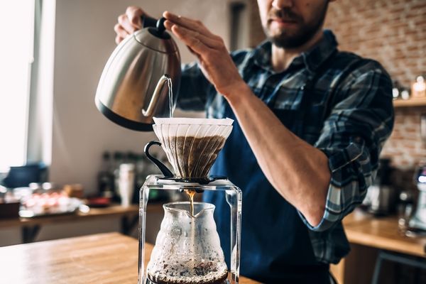 man prepares coffee style pour over
