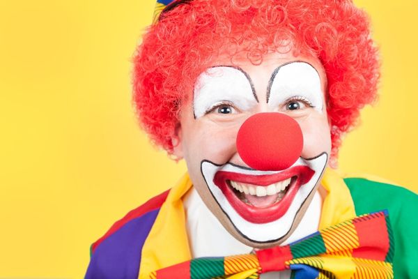 clown close on yellow background red nose