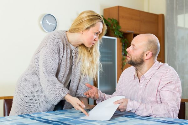 unpleased young couple having conflict over paper
