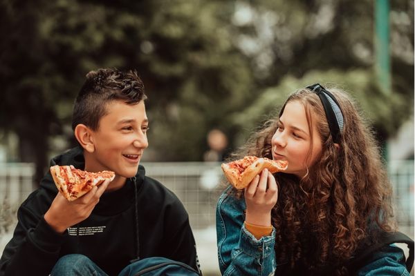 boy girl on lunch break school eating pizza