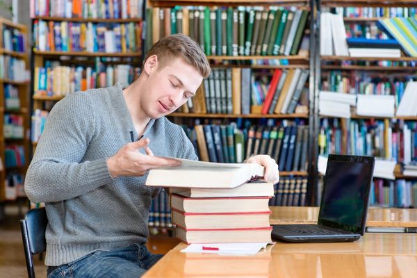 Male student laptop studying university library