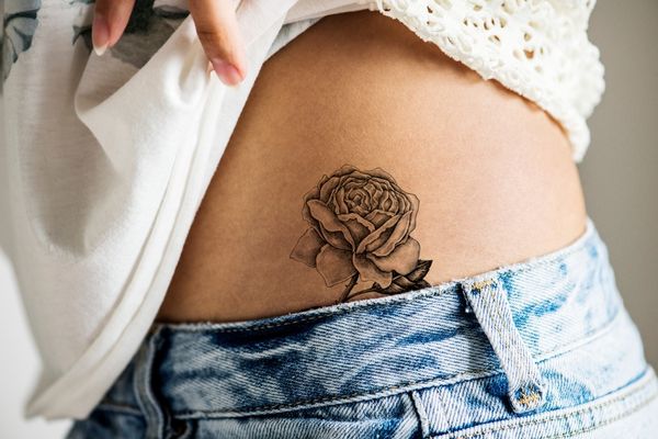 lower hip tattoo woman black ink rose