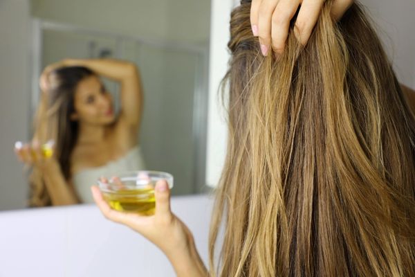 young woman applying olive oil mask