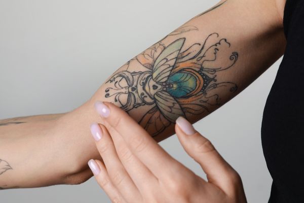 woman applying cream on arm new tattoo
