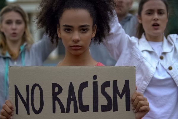 afroamerican girl holding no racism sign