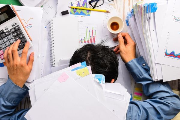 heavy workload sleep office desk finance sheet calculator coffee