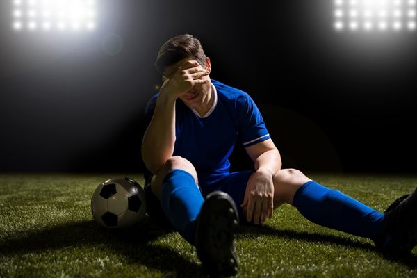 disappointed young man lost game soccer sitting