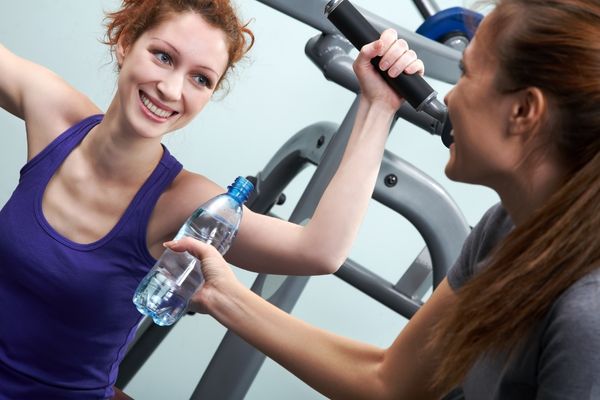woman gym friend giving water