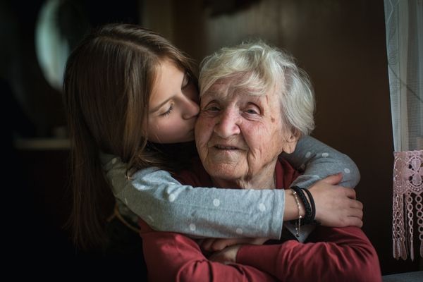 little girl hugs her grandmother kiss happy