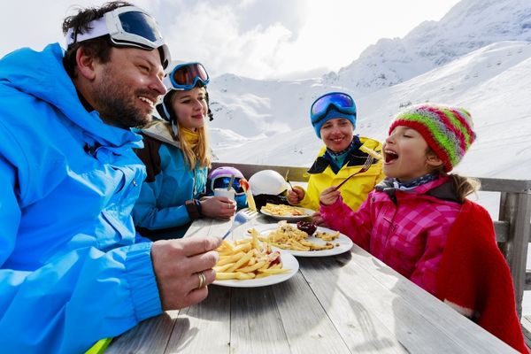 family skiers enjoying lunch winter mountains