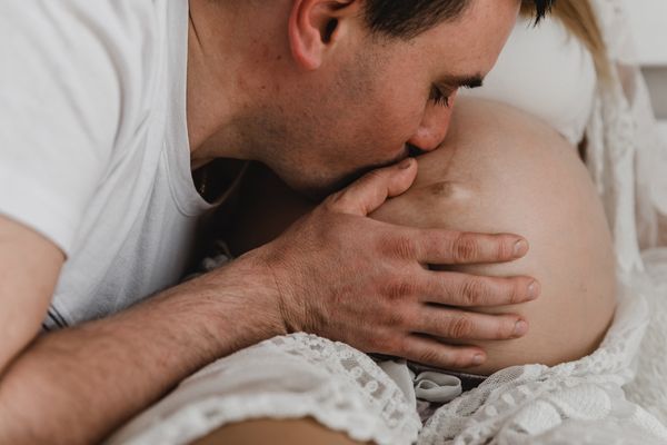 Husband kissing pregnant wife belly tenderly