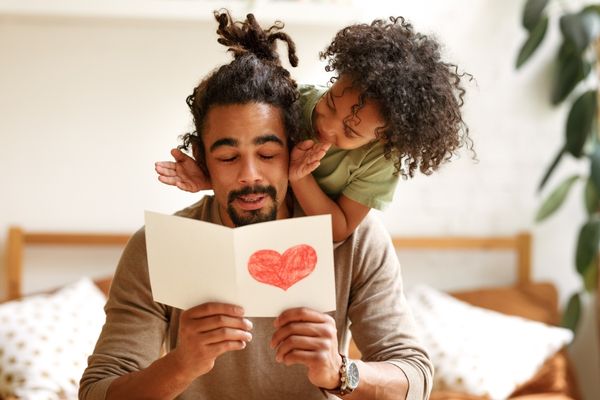 Surprise for daddy afro american kid postcard heart covering his eyes